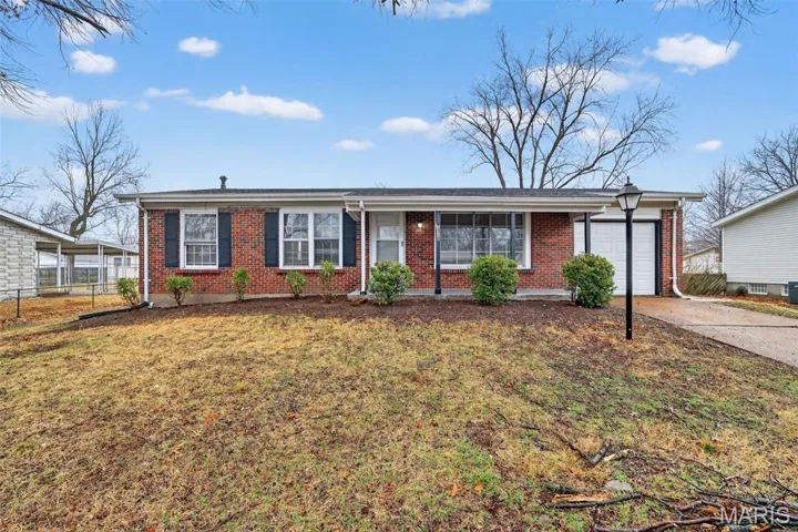 Single story home featuring brick siding, an attached garage, driveway, and covered porch