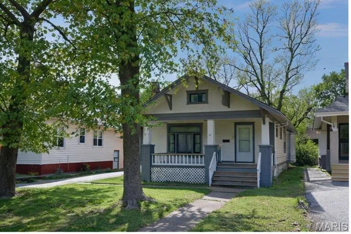 View of front of property with a porch and a front lawn