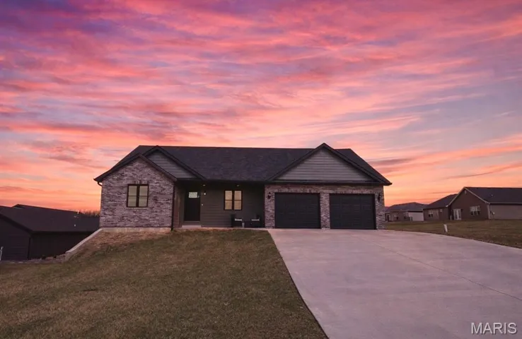 View of front of property with driveway, a front yard, and a porch
