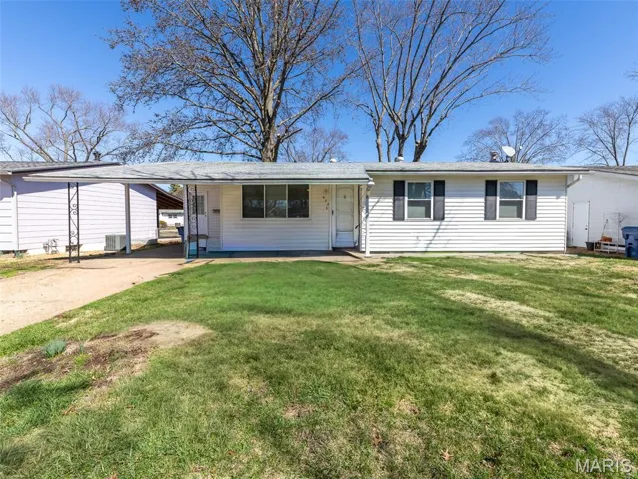 Single story home featuring concrete driveway, a front yard, and a carport