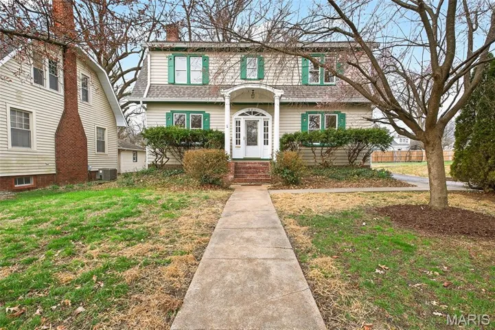 View of front facade with a front lawn and a chimney