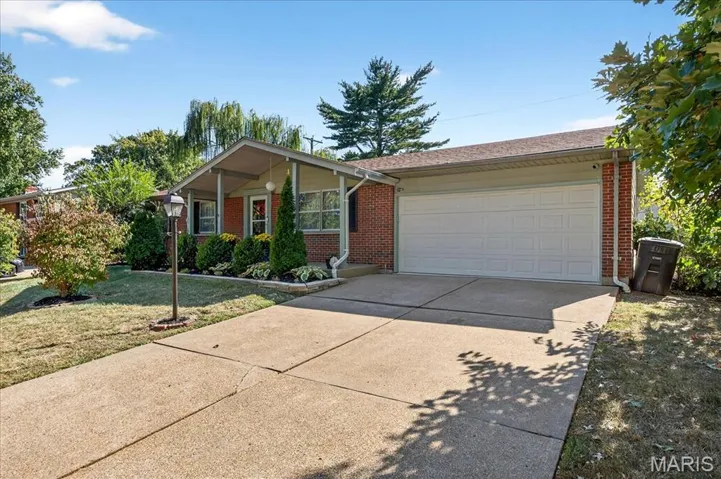 Single story home with driveway, a front lawn, an attached garage, and brick siding