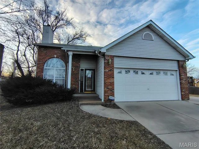 Ranch-style home with an attached garage, driveway, and brick siding