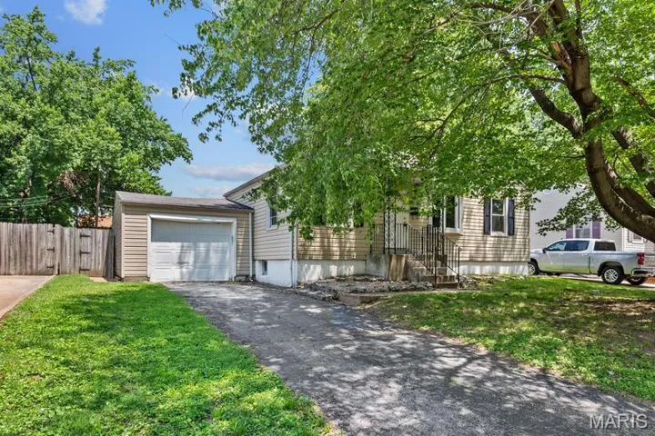View of front of house featuring a garage and a front yard