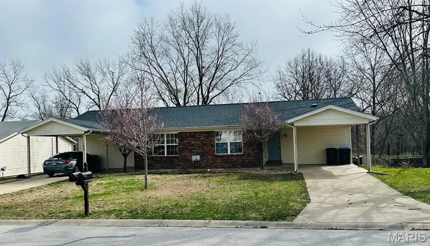 Ranch-style home with an attached carport, a front lawn, concrete driveway, brick siding, and a porch