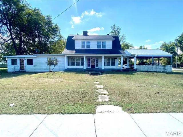 View of front facade featuring a front lawn and covered porch
