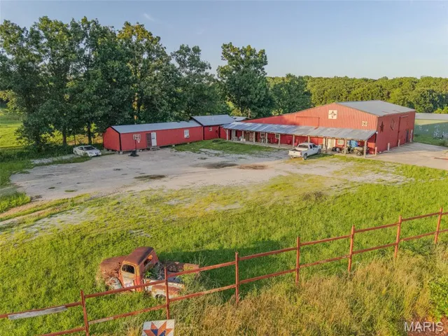View of yard with a pole building, driveway, and an outbuilding