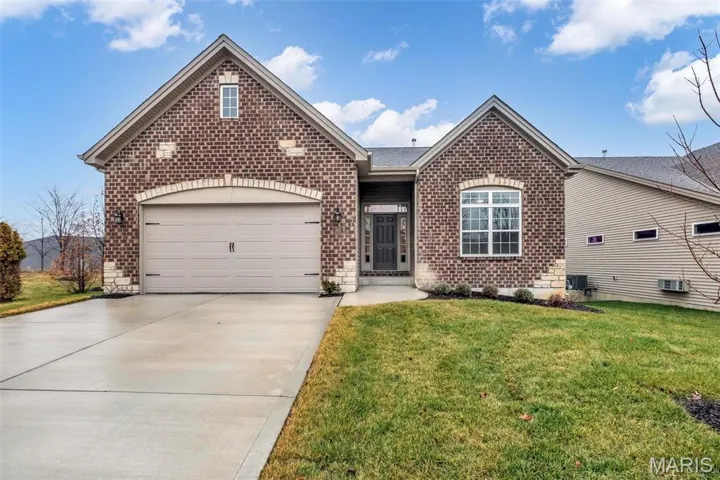 Brick Facade with Stone Accents and a Carriage Style Garage Door