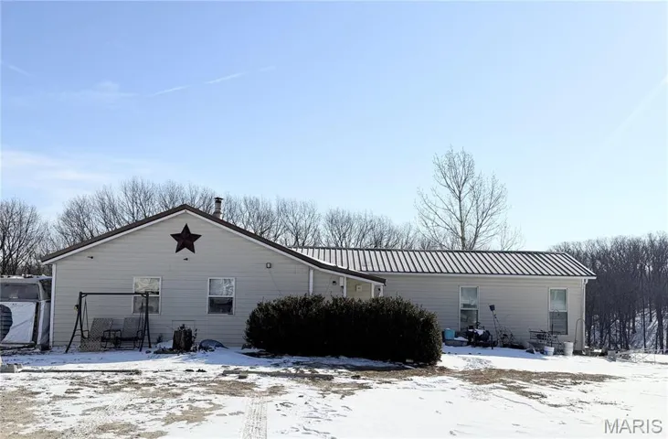 View of snow covered back of property