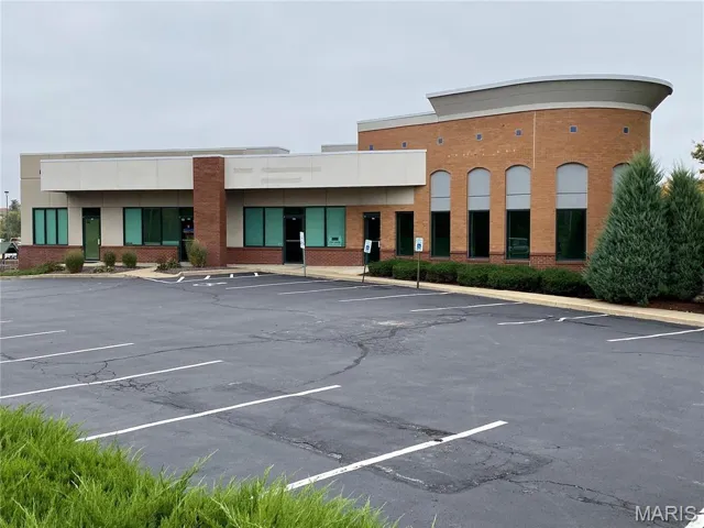 View of building exterior with uncovered parking
