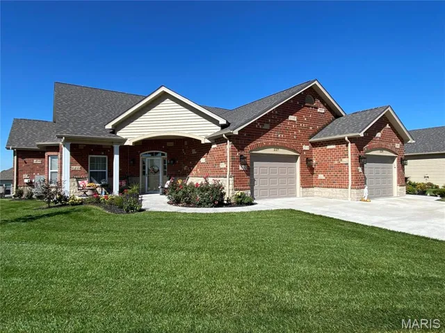 View of front of home with a garage and a front lawn
