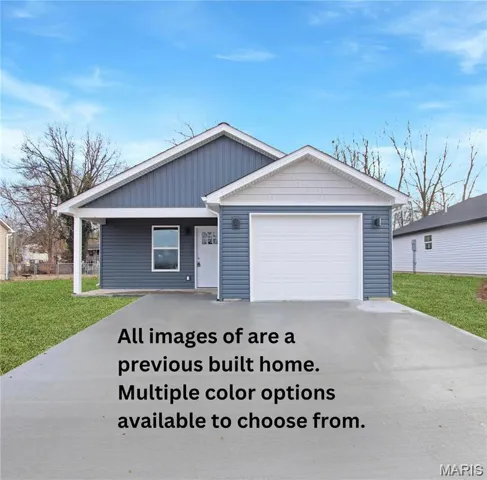 View of front of home featuring driveway, a front lawn, and a garage
