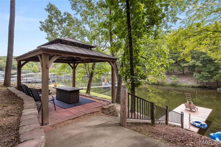 View of patio with a water view and a gazebo