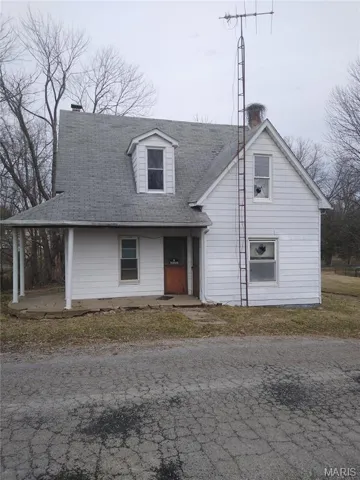 View of front of house with a chimney and roof with shingles