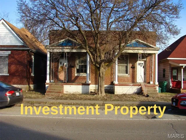 View of front of home with brick siding and a porch