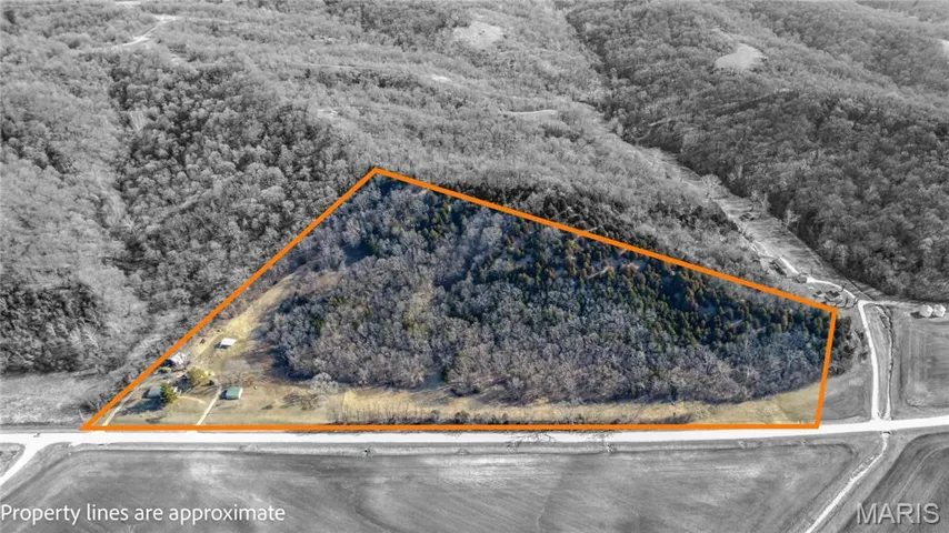 Aerial view of property's location featuring property boundaries highlighted and a heavily wooded area