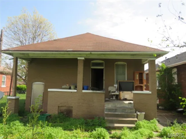 Front view of house with a porch and brick siding