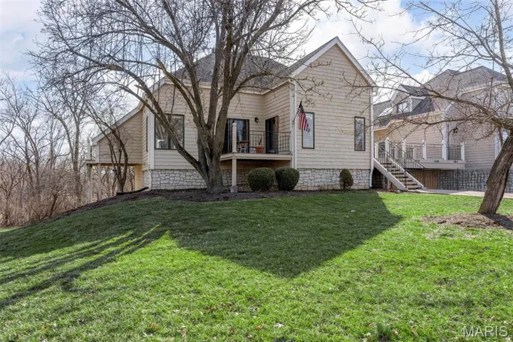 View of front of home with stairway and a front lawn