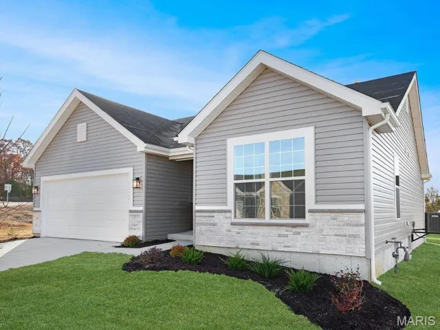 Single story home featuring stone siding, a front lawn, driveway, and an attached garage