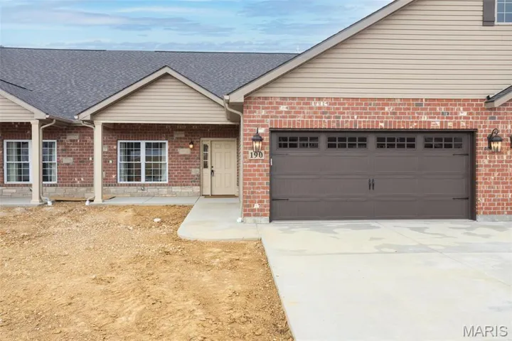 Ranch-style house featuring a garage, brick siding, roof with shingles, and driveway