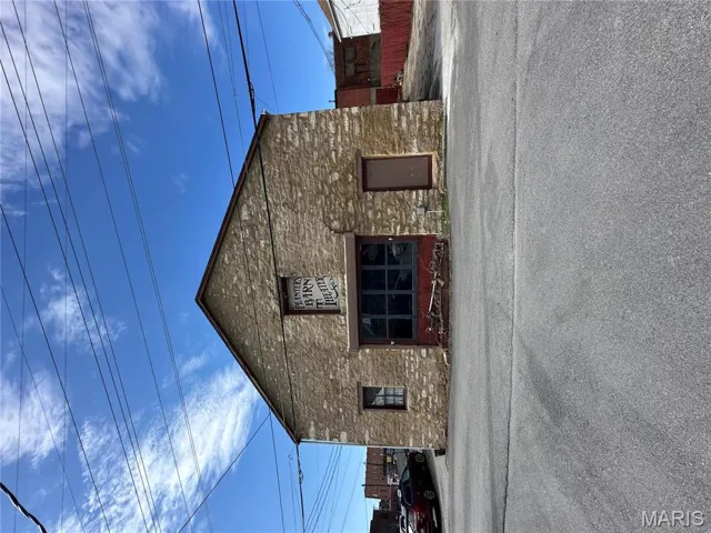 View of home's exterior with stone siding and fence