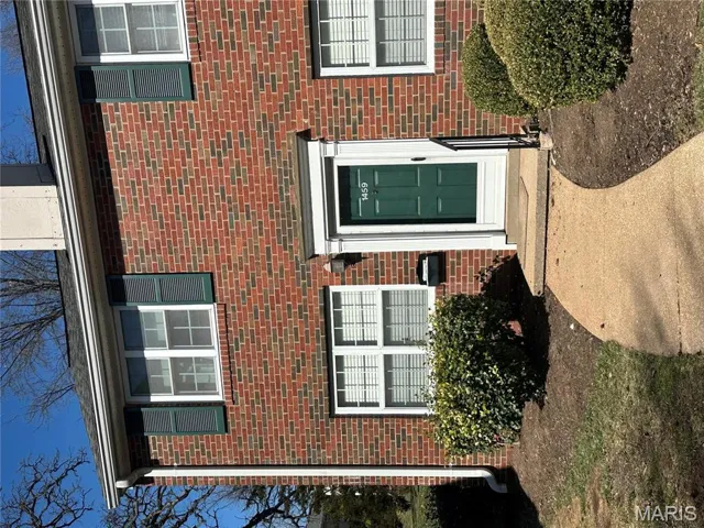 Doorway to property featuring brick siding
