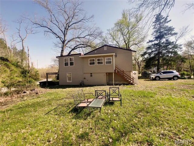 Rear view of property with a lawn