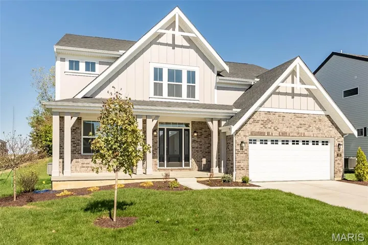 Craftsman-style home with board and batten siding, a porch, brick siding, and a shingled roof