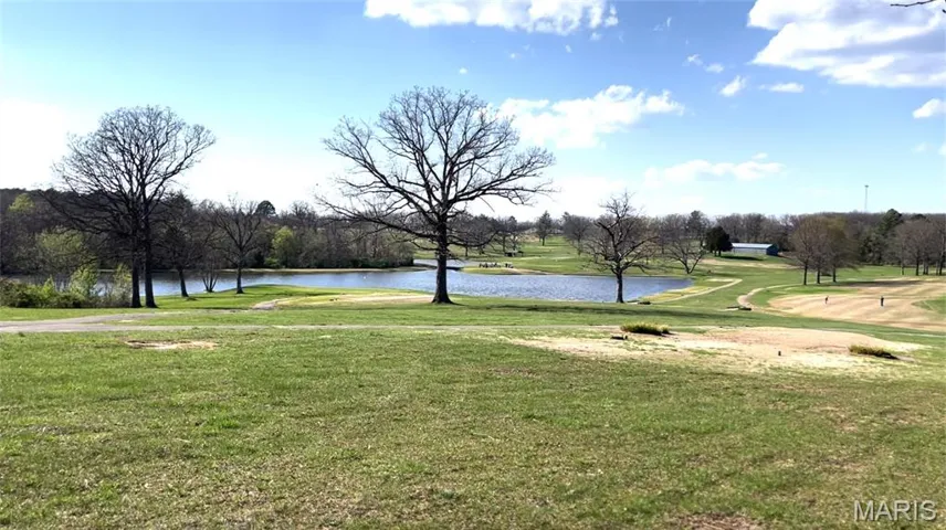 View of community featuring a lawn, a water view, and golf course view