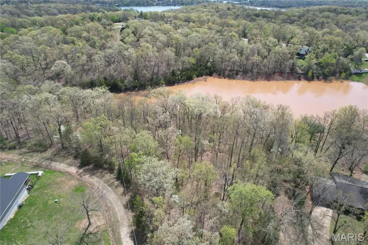 Birds eye view of property featuring a wooded view and a water view