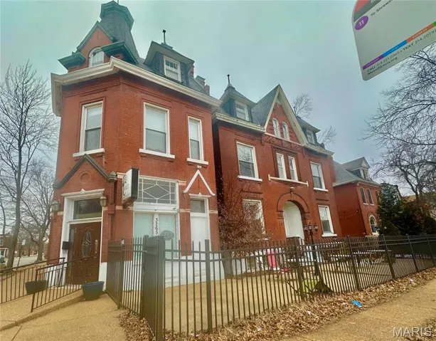 View of front of property with a fenced front yard and brick siding