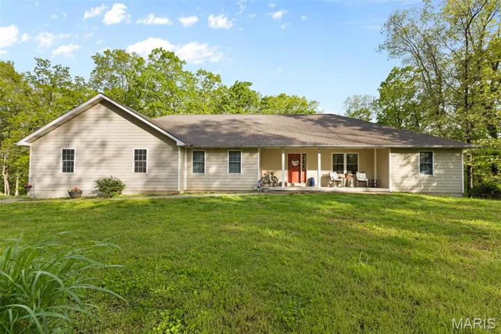 Rear view of house with a lawn and a shingled roof