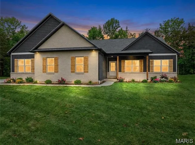 View of front of home with a front lawn, a porch, and brick siding