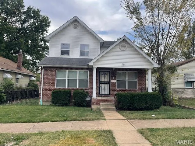 View of front of property with covered porch, brick siding, and a shingled roof