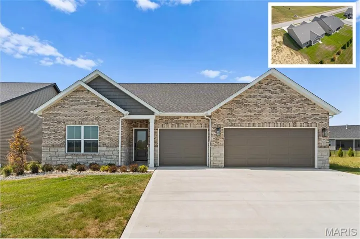 View of front of property featuring stone siding, driveway, a front lawn, a shingled roof, and a garage