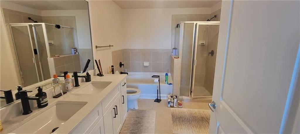 Full bathroom with a bath, a stall shower, and a sink