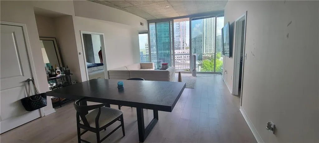 Dining space with light wood-style floors, baseboards, and a wall of windows