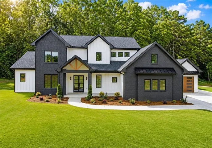 Contemporary two-story residence featuring a striking black brick and white board-and-batten facade