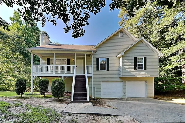 Two-story residence featuring light-colored siding and a covered front porch with white railings