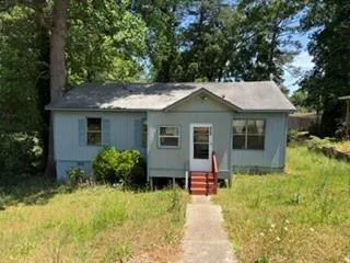 Light blue siding exterior with a pitched roof and a concrete walkway leading to the front entry