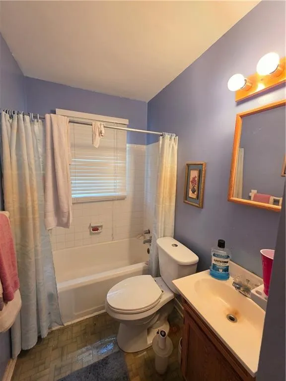 Full bathroom with shower / tub combo and vanity