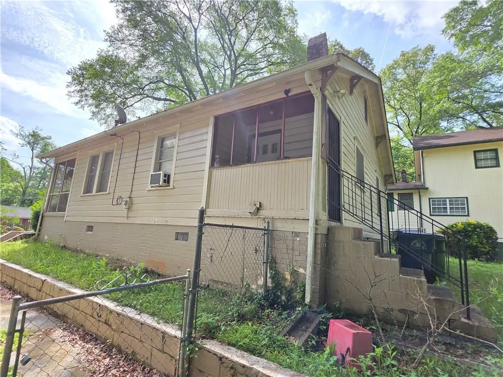 View of side of property featuring crawl space, stairway, a sunroom, cooling unit, and a chimney