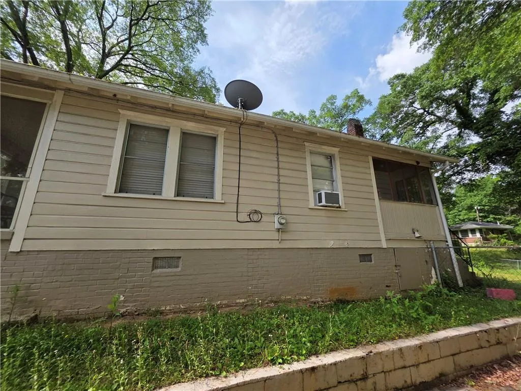 View of side of home with crawl space and a chimney