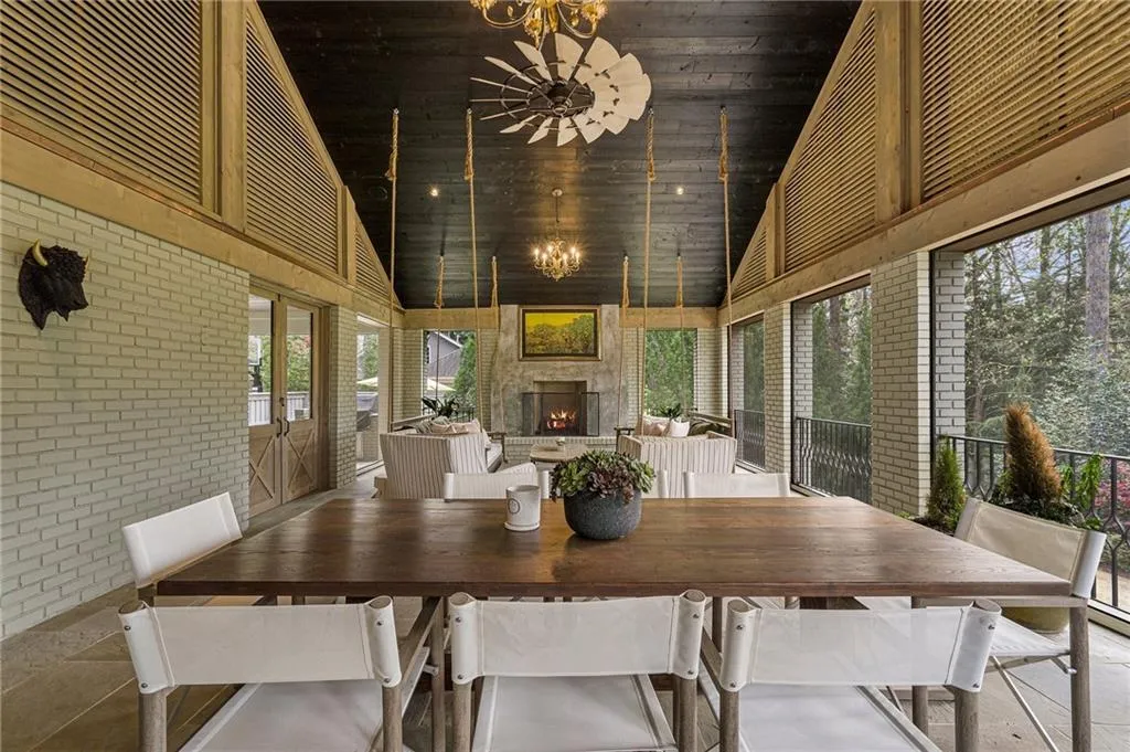 Outdoor dining area with fireplace and retractible screens.