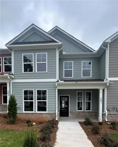 Two-story facade with gabled roof lines, light green siding, white trim, and a covered front entry