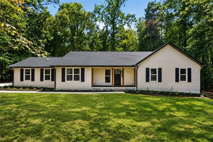 Single-story residence featuring light-colored siding and a dark shingle roof