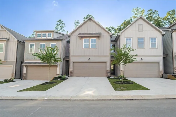 Modern townhome exterior with a pitched roof, vertical siding, and an attached two-car garage