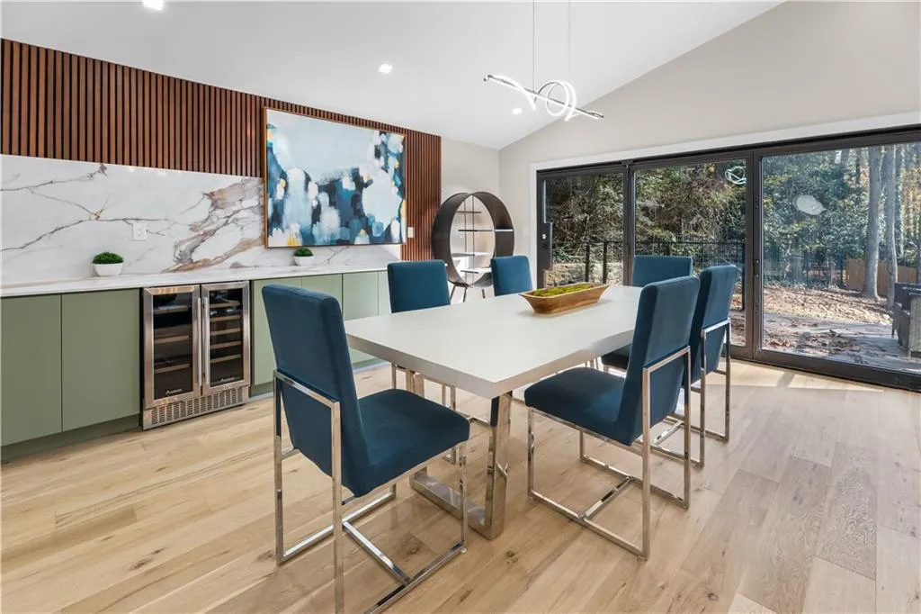 Dining room featuring beverage cooler, lofted ceiling, light wood-style flooring, and recessed lighting
