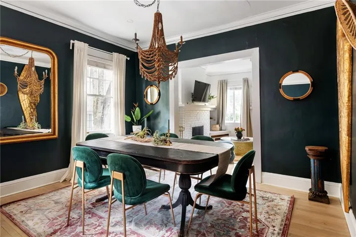 Hardwood flooring, crown molding, white trim, recessed window, and a built-in chandelier
