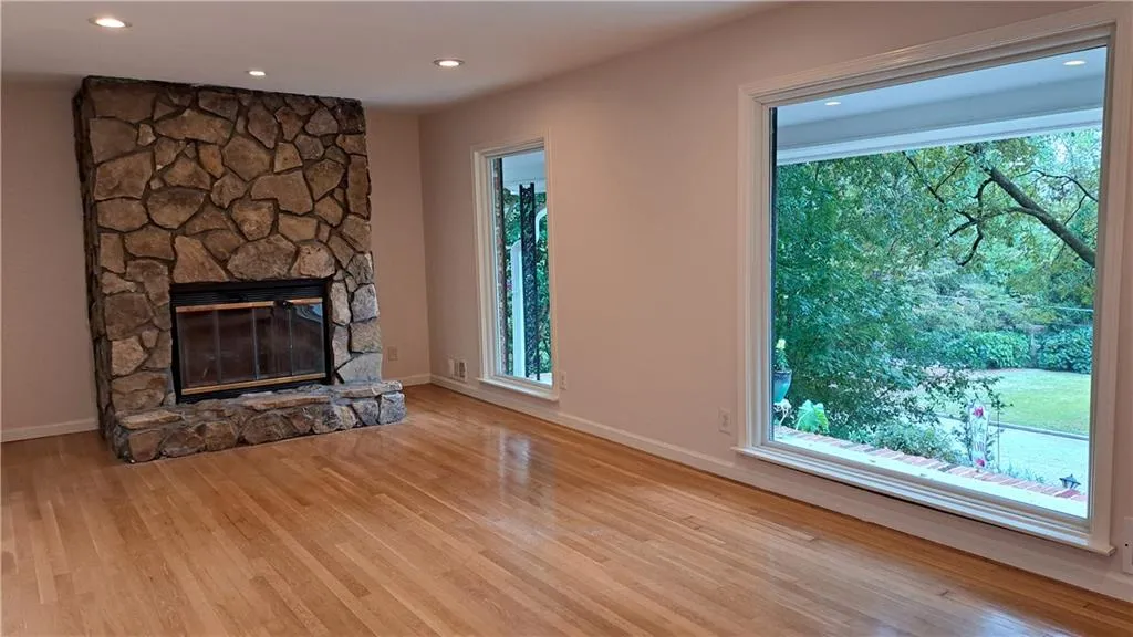 Living Room (unfurnished) with woodburning fireplace and stone facade/mantle